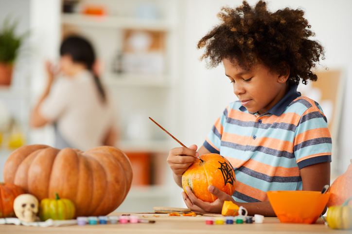 Kid carving pumpkin. 